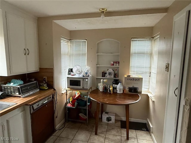 20614 Kings Hwy, Warrensville Heights, OH 44122 - kitchen featuring light tile patterned floors, black dishwasher, wooden counters, white microwave, and white cabinetry