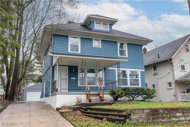 american foursquare style home with an outbuilding, a porch, and a garage
