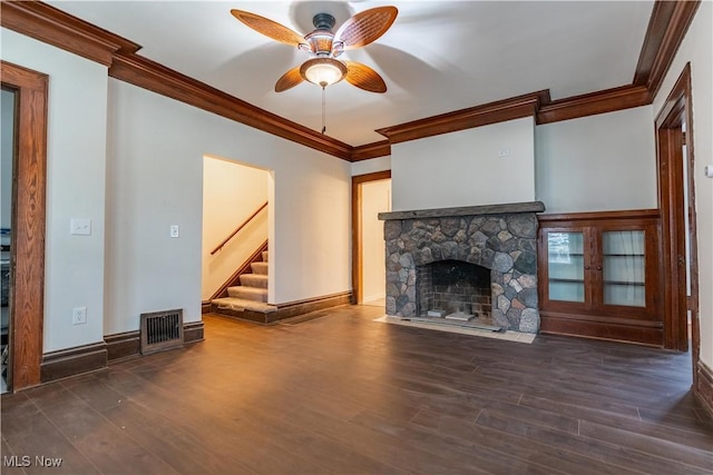 unfurnished living room with stairs, visible vents, crown molding, and wood finished floors