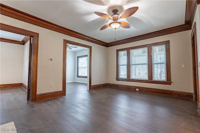 spare room with ornamental molding, baseboards, a ceiling fan, and dark wood finished floors