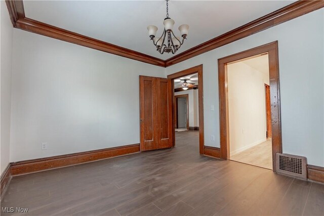 unfurnished room featuring visible vents, baseboards, a chandelier, crown molding, and wood finished floors