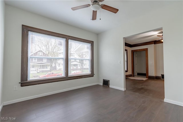 unfurnished room with dark wood finished floors, baseboards, and ceiling fan