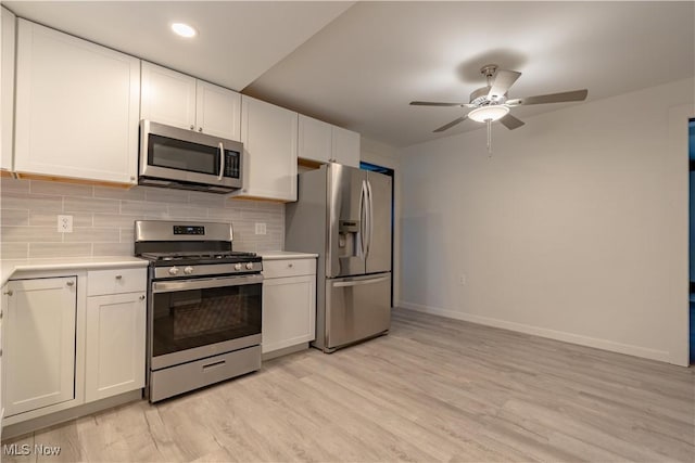 kitchen featuring ceiling fan, appliances with stainless steel finishes, light countertops, baseboards, and backsplash