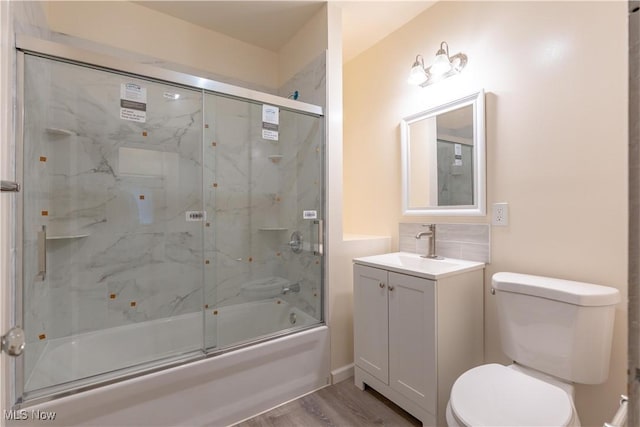 full bathroom featuring enclosed tub / shower combo, vanity, toilet, and wood finished floors