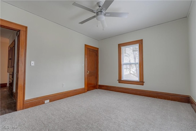 carpeted empty room with ceiling fan and baseboards