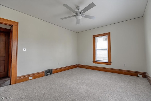 empty room with visible vents, baseboards, a ceiling fan, and carpet flooring