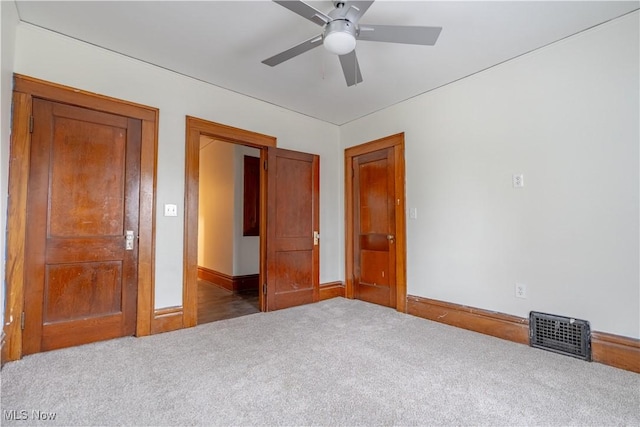 unfurnished bedroom with visible vents, baseboards, a ceiling fan, and carpet flooring