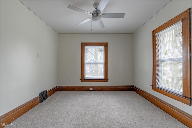 unfurnished room featuring carpet flooring, baseboards, and a ceiling fan
