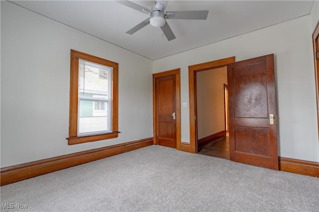 unfurnished bedroom with baseboards, a ceiling fan, and carpet