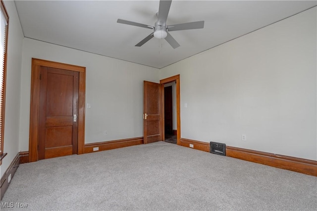 empty room featuring visible vents, ceiling fan, carpet, and baseboards