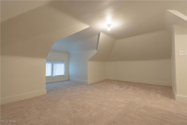 bonus room with carpet floors, baseboards, and vaulted ceiling