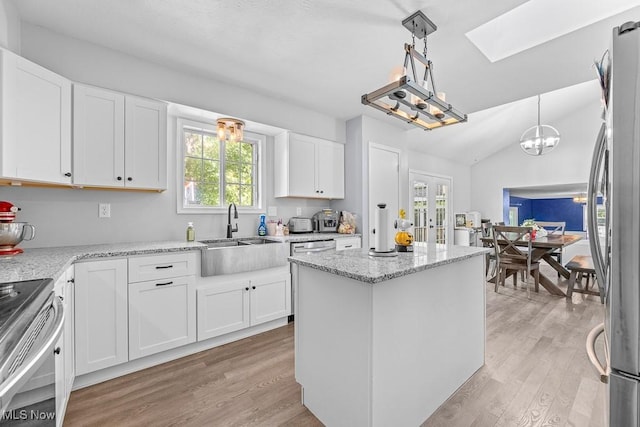 7319 Guilford Rd, Seville, OH 44273 - kitchen featuring a center island, appliances with stainless steel finishes, a sink, and light wood-style floors
