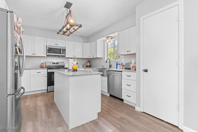 7319 Guilford Rd, Seville, OH 44273 - kitchen featuring white cabinets, light wood finished floors, a sink, and appliances with stainless steel finishes