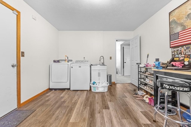 7319 Guilford Rd, Seville, OH 44273 - washroom featuring separate washer and dryer, wood finished floors, a sink, baseboards, and cabinet space