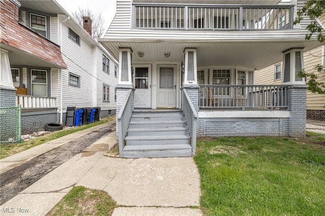 entrance to property with a porch and a balcony