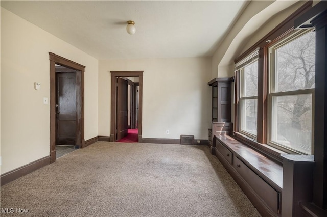 carpeted empty room with baseboards