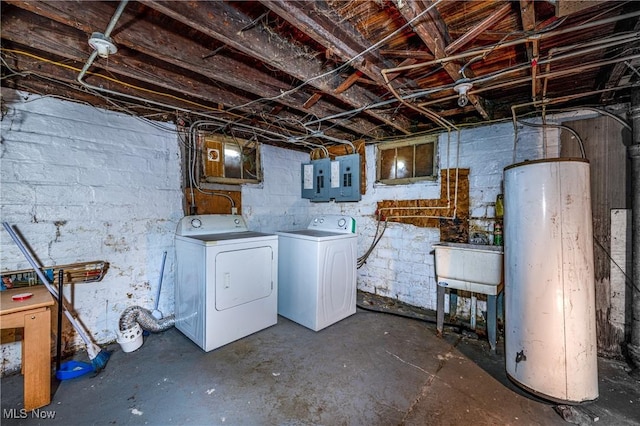 unfinished below grade area featuring water heater, washing machine and dryer, electric panel, and a sink