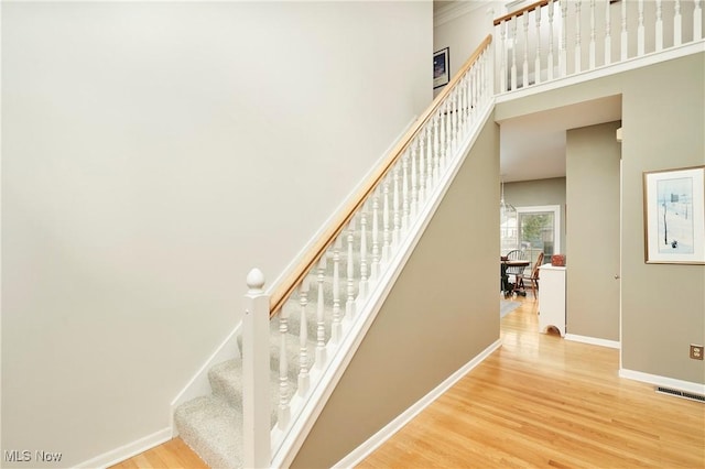4339 Sierra Dr, Copley, OH 44321 - staircase with wood finished floors, a high ceiling, baseboards, and visible vents