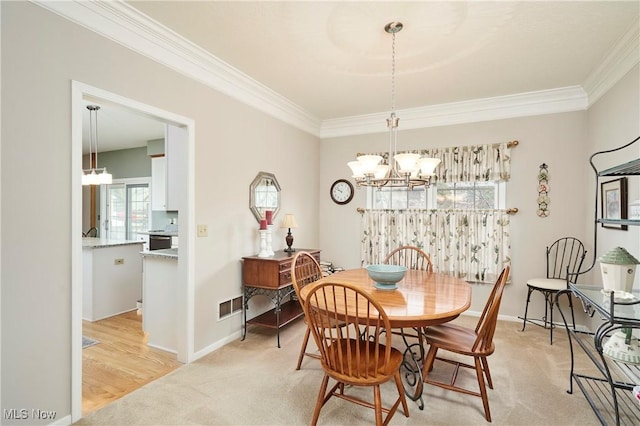 4339 Sierra Dr, Copley, OH 44321 - dining space featuring light carpet, visible vents, a chandelier, and ornamental molding