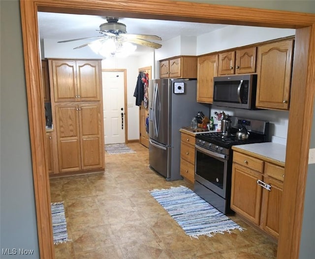 kitchen featuring light countertops, brown cabinets, a ceiling fan, and appliances with stainless steel finishes