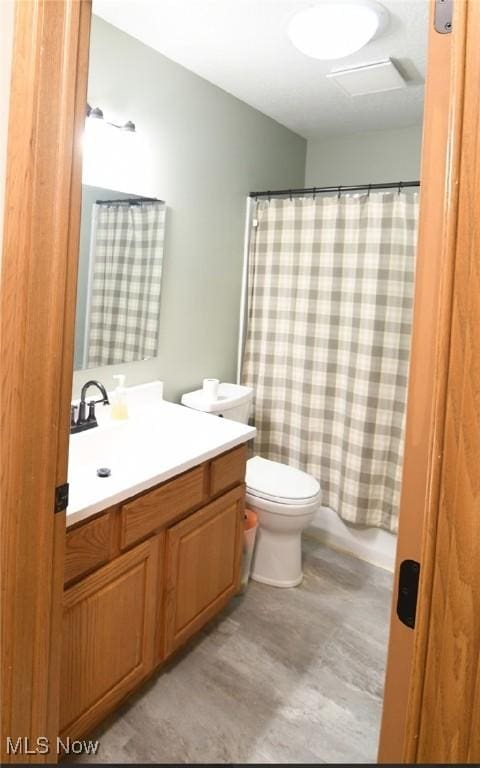 full bathroom featuring toilet, a shower with curtain, vanity, and wood finished floors