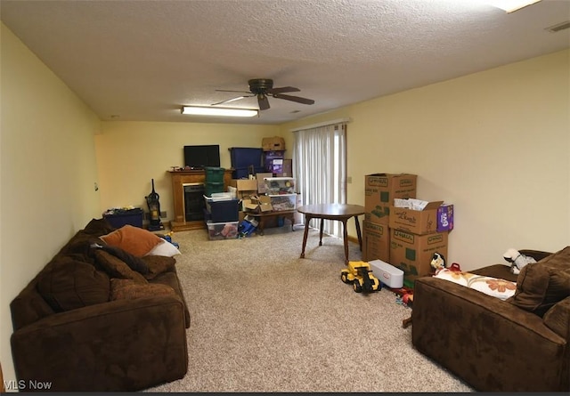 living area featuring a textured ceiling, visible vents, ceiling fan, and carpet
