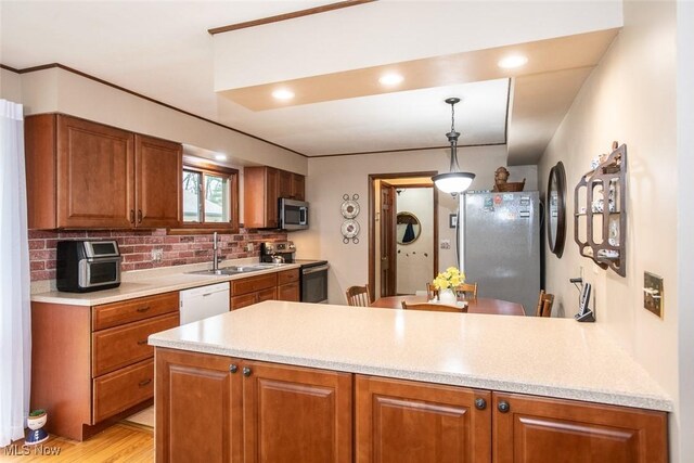 3035 Hamilton Rd, Medina, OH 44256 - kitchen featuring a sink, light countertops, a peninsula, brown cabinetry, and stainless steel appliances