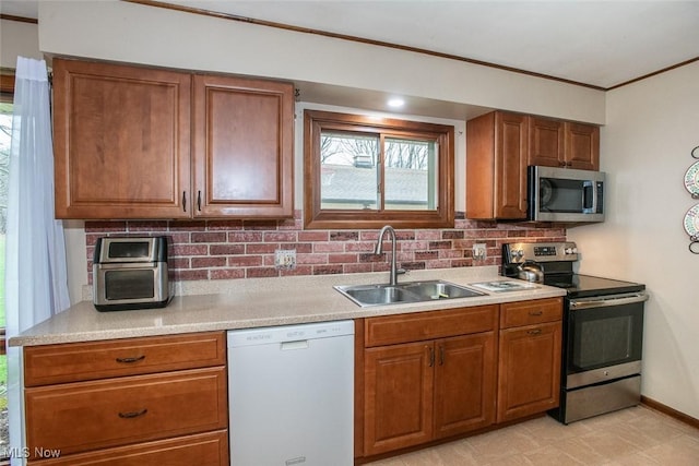 3035 Hamilton Rd, Medina, OH 44256 - kitchen with a sink, brown cabinets, crown molding, stainless steel appliances, and backsplash