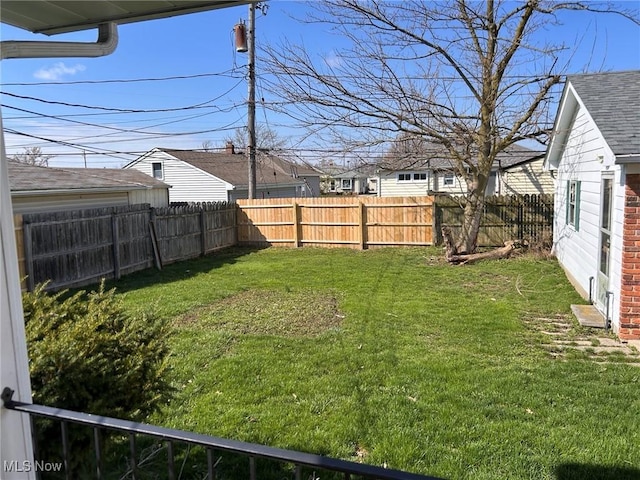 view of yard featuring a fenced backyard and a residential view