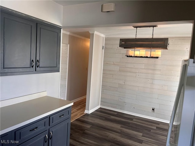 unfurnished dining area with dark wood-type flooring, baseboards, and ornamental molding