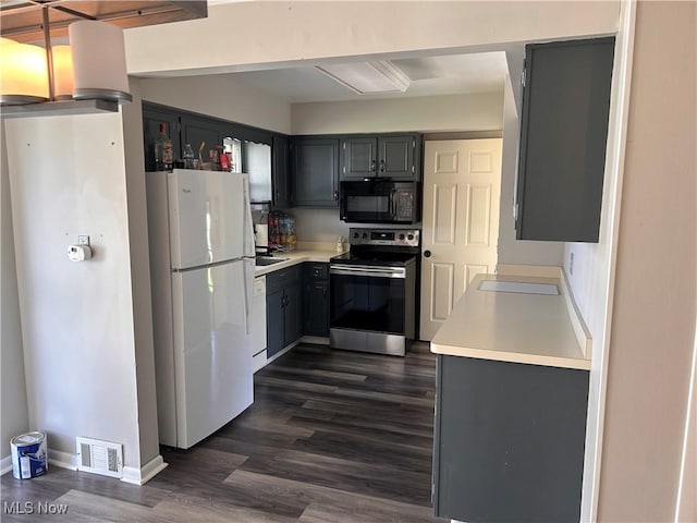kitchen with white appliances, visible vents, gray cabinets, dark wood-style flooring, and light countertops