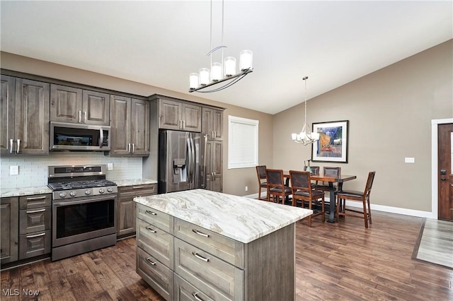 810 Point Dr, Akron, OH 44319 - kitchen featuring an inviting chandelier, dark wood-style flooring, appliances with stainless steel finishes, backsplash, and lofted ceiling