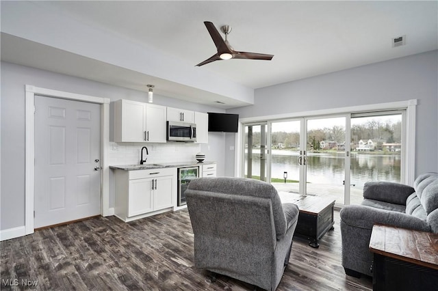 810 Point Dr, Akron, OH 44319 - living room with indoor wet bar, dark wood-style flooring, a ceiling fan, visible vents, and wine cooler