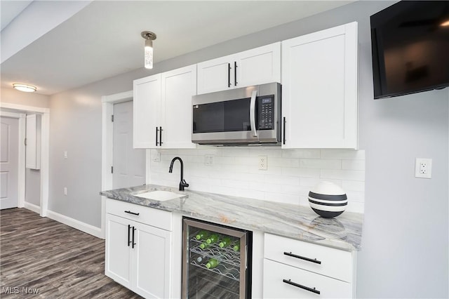 810 Point Dr, Akron, OH 44319 - kitchen with baseboards, a sink, stainless steel microwave, backsplash, and beverage cooler