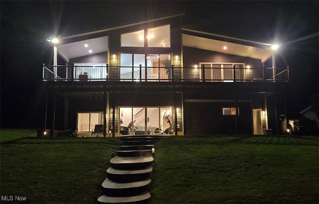 810 Point Dr, Akron, OH 44319 - back of house at night with stairs, a deck, and a lawn