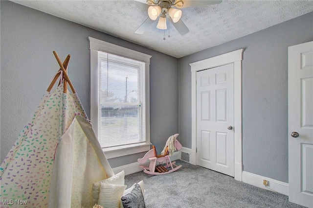 playroom with baseboards, a ceiling fan, and carpet flooring