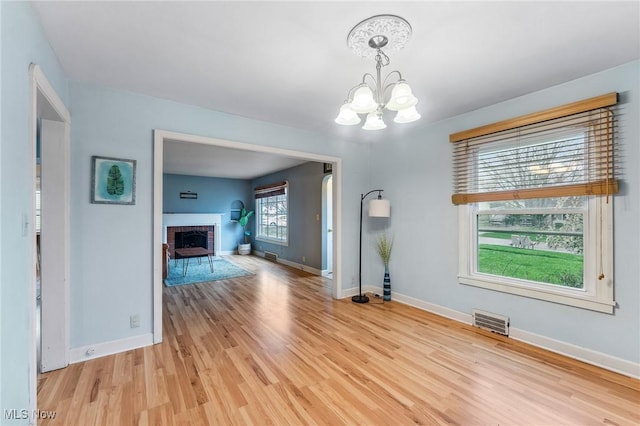 43 Hamilton Ave, Poland, OH 44514 - unfurnished living room featuring a chandelier, visible vents, light wood-type flooring, and baseboards