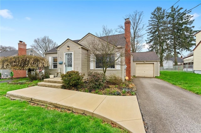 43 Hamilton Ave, Poland, OH 44514 - bungalow-style house featuring an attached garage, a chimney, aphalt driveway, fence, and a front lawn