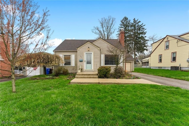 43 Hamilton Ave, Poland, OH 44514 - view of front facade featuring a chimney, a front yard, and central AC
