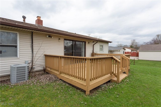 rear view of property with central AC unit, a deck, a lawn, and a chimney