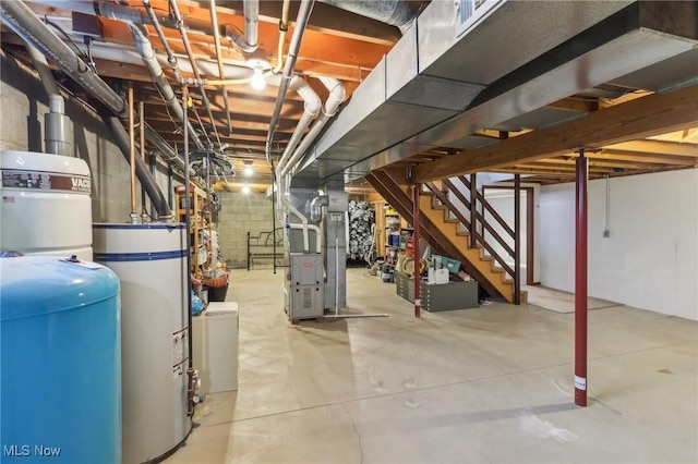 unfinished below grade area with stairway, heating unit, gas water heater, and concrete block wall