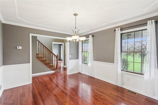 unfurnished dining area with stairs, visible vents, an inviting chandelier, and wood finished floors