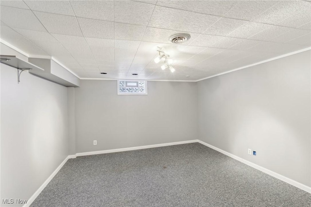 below grade area featuring ornamental molding, carpet floors, and baseboards