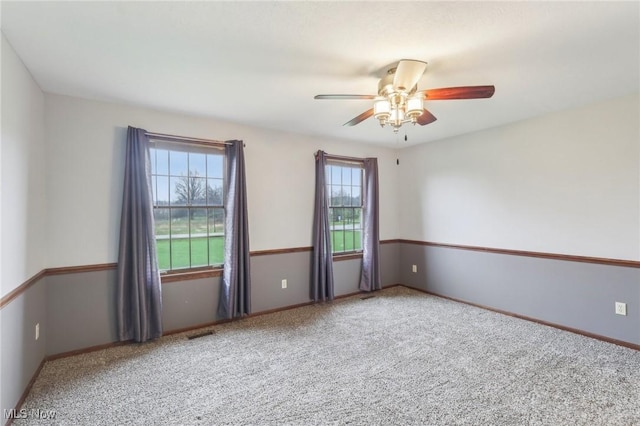 spare room with visible vents, baseboards, a ceiling fan, and carpet