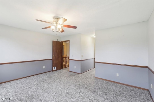 unfurnished room featuring carpet floors, baseboards, a ceiling fan, and visible vents