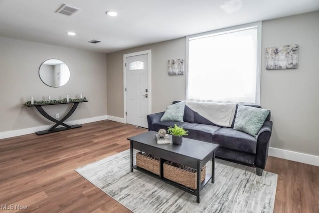 living room featuring recessed lighting, visible vents, baseboards, and wood finished floors