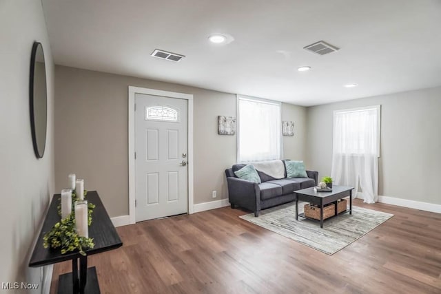 living area featuring wood finished floors, baseboards, and visible vents