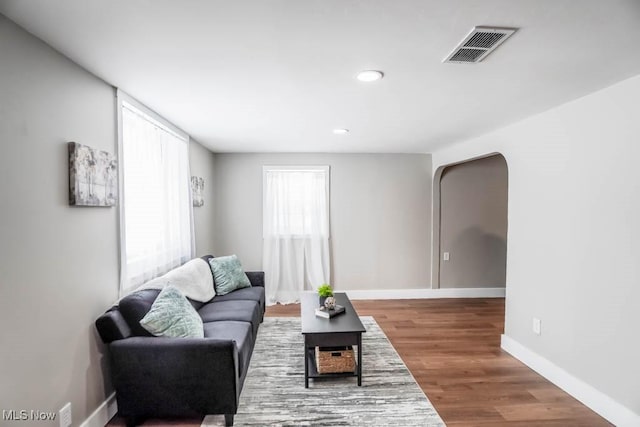 living area with visible vents, baseboards, recessed lighting, and wood finished floors