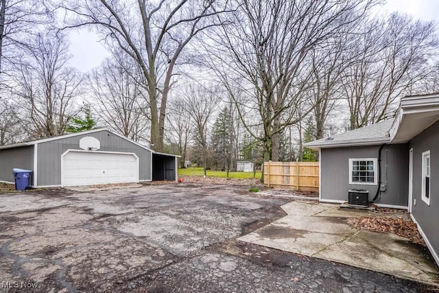 detached garage with central air condition unit and fence