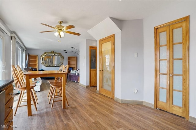 dining room featuring baseboards, a ceiling fan, and wood finished floors